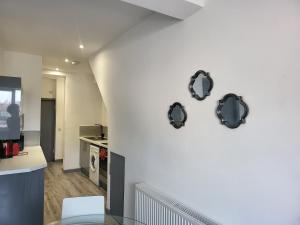 a kitchen with four mirrors on a wall at Vetrelax Southend Apartment in Westcliff-On-Sea