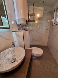 a bathroom with a sink and a toilet at Apartman Katarina Promajna in Promajna +26 photos