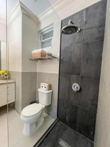a bathroom with a toilet and a shower at Choose To Be Happy at EI8HT! - Super Studios and Penthouse Apartment in Kingston