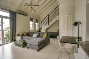 a living room with a couch and a chair at Choose To Be Happy at EI8HT! - Super Studios and Penthouse Apartment in Kingston