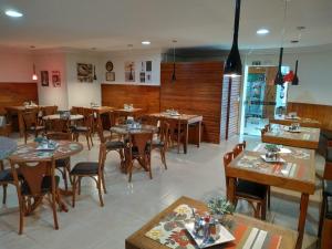 a restaurant with wooden tables and chairs in a room at ROMA'S HOTEL in Umuarama