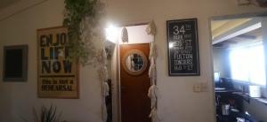 Un pasillo con una puerta con un cartel. en La Casita de Saavedra en Buenos Aires