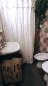 y baño con lavabo y aseo. en La Casita de Saavedra en Buenos Aires