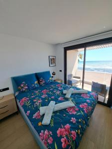 a bedroom with a bed with a blue blanket with flowers at Luxury Apartment La Mata right by the sea in La Mata