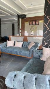 a living room with a blue couch with pillows at اوركيدا الشمال للشقق الفندقية in Al Mafraq