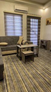 a living room with a couch and a coffee table at اوركيدا الشمال للشقق الفندقية in Al Mafraq