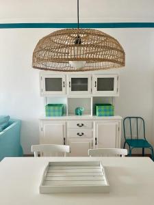 een kamer met een witte tafel met stoelen en een licht bij Miralago Casa Vacanze in Riva di Solto