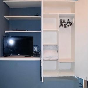 a white book shelf with a tv in a room at Linda casa em Geribá in Búzios