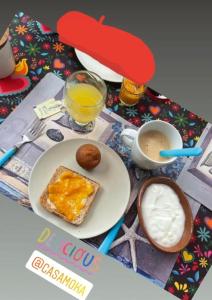 uma mesa com um prato de torradas e uma chávena de sumo de laranja em Casa Moka em Peñita de Jaltemba