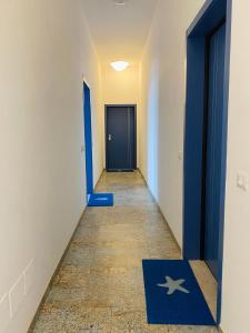 a hallway with a blue door and a star rug at Suite vista mare in Gaeta