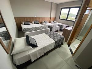 eine Gruppe von 4 Betten in einem Zimmer in der Unterkunft VIPPER Hotel in Aparecida