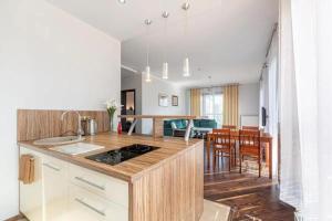 Il comprend une cuisine équipée d'une cuisinière et d'une salle à manger. dans l'établissement Central Apartments Sz 5-28, à Gdańsk