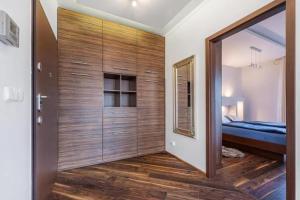 Cette chambre est dotée d'un grand mur en bois et d'un lit. dans l'établissement Central Apartments Sz 5-28, à Gdańsk