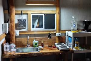 a kitchen counter with a sink and a microwave at GLAMPING BAReKE AZUL2 in Santa Marta
