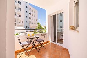 a balcony with a table and chairs on a balcony at Elegante piso en la Romanilla in Roquetas de Mar