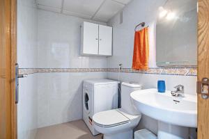 a white bathroom with a toilet and a sink at Elegante piso en la Romanilla in Roquetas de Mar +35 photos