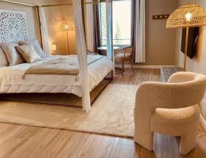 a bedroom with a bed and a chair at La Lagune Panoramic View in Bages