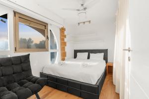 um quarto com uma cama, uma cadeira e uma janela em The gaudi house TLV em Tel Aviv