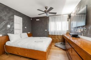 a bedroom with a bed and a ceiling fan at The gaudi house TLV in Tel Aviv