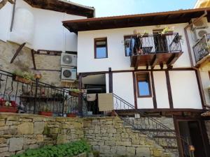 una casa con balcones y escaleras en una localidad en Стаи за гости Елеганс en Elena