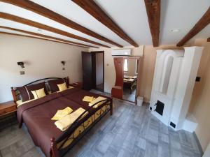 a bedroom with a large bed and a fireplace at Стаи за гости Елеганс in Elena