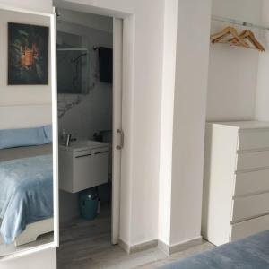 een slaapkamer met een spiegel, een bed en een wastafel bij "Casa Jasmin" 14 Calle Medina Quesada in Tazacorte