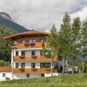 a building with a balcony with flowers on it at Ottohof - Morgenrot in Brennero