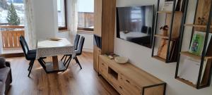 a living room with a dining room table and a television at Ottohof - Morgenrot in Brennero