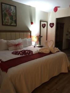 a bedroom with a large bed with a heart decoration on it at Hotel JYE by Serranillo, Mineral del Monte Hgo in Mineral del Monte