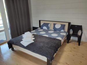 un letto con cuscini blu e una sedia in una stanza di Hotel Osher a Bukovel