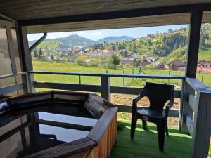 a chair sitting on a porch with a view of a field at Hotel Osher in Bukovel
