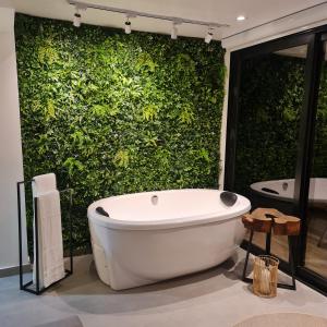 a white bath tub in front of a green wall at Casa Container - Haupt Village in Farroupilha