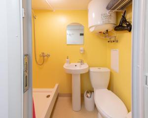 a yellow bathroom with a toilet and a sink at "Ваша Квартира" - у самого Дерибаса! "Ваша Квартира" біля самого Дерибаса! in Odesa