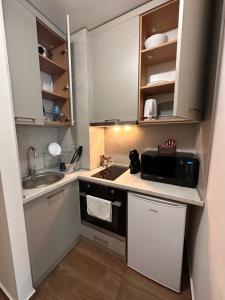 eine kleine Küche mit einer Spüle und einer Mikrowelle in der Unterkunft Borovets Gardens Studio in Borowez