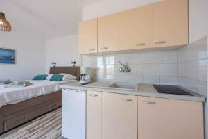 a kitchen with a sink and a bed in a room at Studio Crikvenica 6 in Dramalj