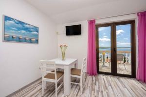 a room with a table and a window with pink curtains at Studio Crikvenica 6 in Dramalj