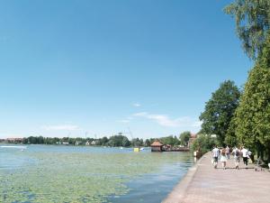 a group of people walking on a sidewalk next to a river at Wodniak in Ostróda