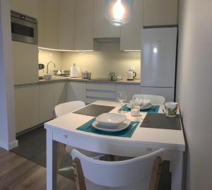 Una cocina con una mesa con platos y copas de vino. en Wodniak, en Ostróda 15 fotos más