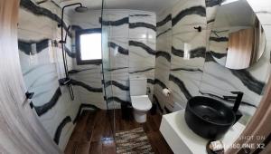 ein Bad mit einem WC und einem schwarzen Waschbecken in der Unterkunft Stream House - Luxury living next to the river in Samothráki