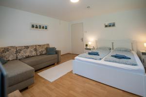 a living room with a bed and a couch at Villa Harmónia Apartman in Visegrád