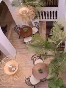 un pasillo con mesas, sillas y palmeras en Hotel Casa Agustina, en Cartagena de Indias