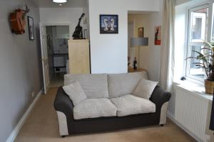 un sofá blanco en una sala de estar con ventana en Beautiful studio in Ely en Ely