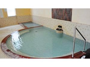 una gran piscina de agua en una bañera en Onsen Hotel Tsutsujiso - Vacation STAY 03256v en Kitami