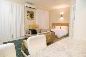 un soggiorno con un divano e un letto di Choose To Be Happy at EI8HT! - Super Studios and Penthouse Apartment a Kingston
