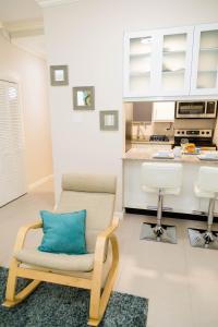 a chair with a blue pillow in a kitchen at Choose To Be Happy at EI8HT! - Super Studios and Penthouse Apartment in Kingston