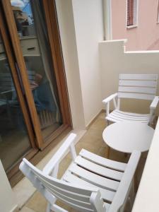2 sillas blancas y una mesa en el balcón en Leli House, en La Canea