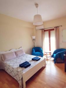 1 dormitorio con 1 cama y 2 sillas azules en Leli House, en La Canea