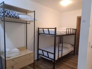 Pokój z 2 łóżkami piętrowymi i drewnianą szafką w obiekcie Casa Wald w mieście Campos do Jordão