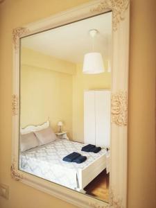 espejo que refleja un dormitorio con cama. en Leli House, en La Canea