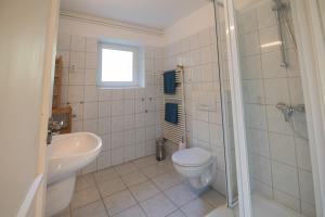 a bathroom with a toilet and a sink and a shower at Villa Harmónia Apartman in Visegrád